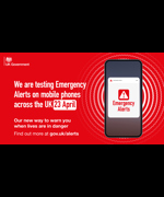 A phone showing a warning. Text to the left reads "We are testing Emergency Alerts on mobile phones across the UK 23 April. On our way to warn you when lives are in danger"